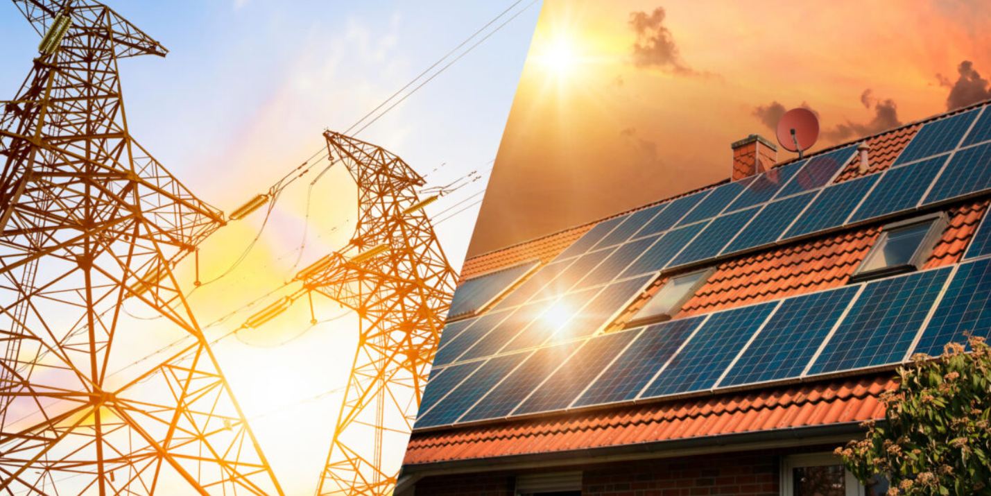 Transmission towers at sunset alongside a rooftop solar panel array